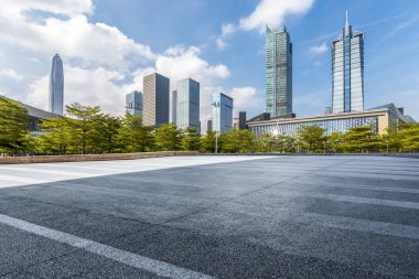 Panoramik siluet ve boş yolu, boş beton zemini olan modern iş binaları.