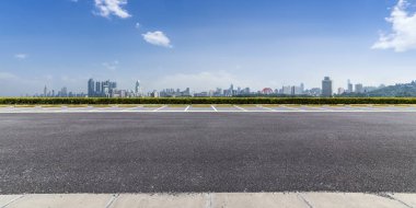 Panoramik siluet ve boş yolu, boş beton zemini olan modern iş binaları.