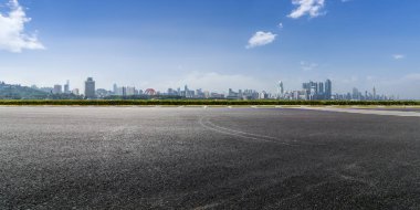 Panoramik siluet ve boş yolu, boş beton zemini olan modern iş binaları.
