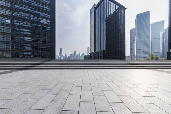 Panoramik siluet ve boş yolu, boş beton zemini olan modern iş binaları.