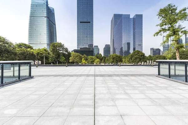 Panoramik siluet ve boş yolu, boş beton zemini olan modern iş binaları.
