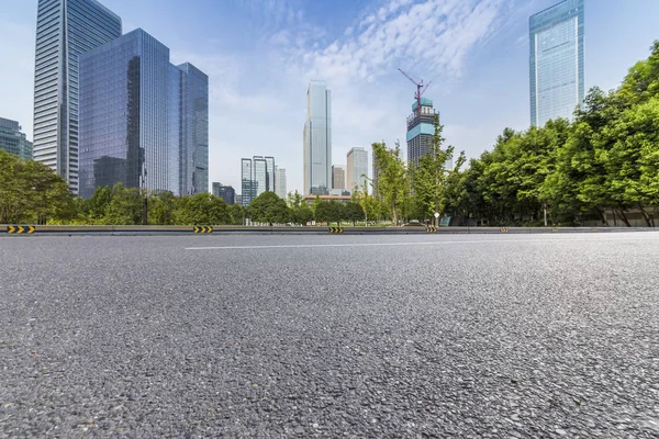 Panoramik siluet ve boş yolu, boş beton zemini olan modern iş binaları.