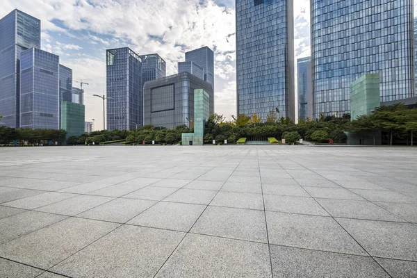 Panoramik siluet ve boş yolu, boş beton zemini olan modern iş binaları.