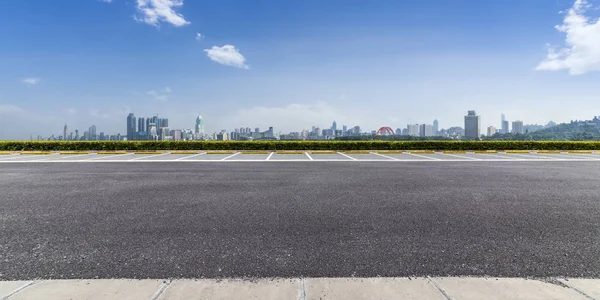 Panoramik siluet ve boş yolu, boş beton zemini olan modern iş binaları.