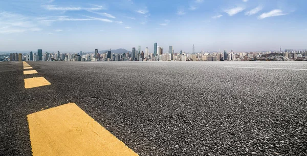 Panoramik siluet ve boş yolu, boş beton zemini olan modern iş binaları.