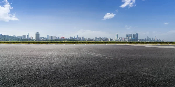 Panoramik siluet ve boş yolu, boş beton zemini olan modern iş binaları.