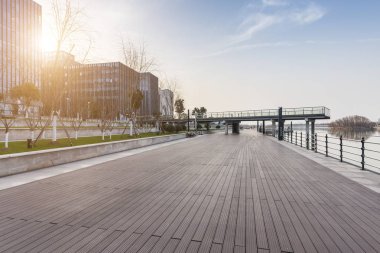 Panoramik siluet ve boş yolu, boş beton zemini olan modern iş binaları.