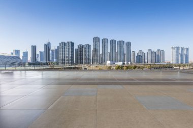 Panoramik siluet ve boş yolu, boş beton zemini olan modern iş binaları.