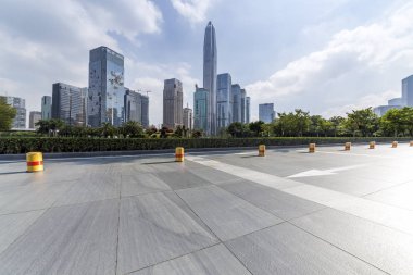 Panoramik siluet ve boş yolu, boş beton zemini olan modern iş binaları.