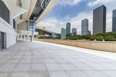 Panoramik siluet ve boş yolu, boş beton zemini olan modern iş binaları.