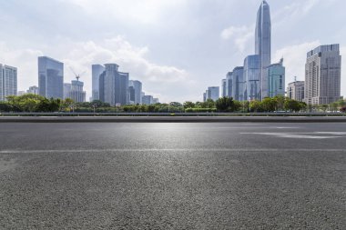 Panoramik siluet ve boş yolu, boş beton zemini olan modern iş binaları.