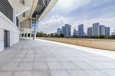 Panoramik siluet ve boş yolu, boş beton zemini olan modern iş binaları.