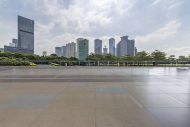 Panoramik siluet ve boş yolu, boş beton zemini olan modern iş binaları.