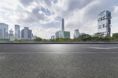 Panoramik siluet ve boş yolu, boş beton zemini olan modern iş binaları.