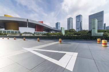 Panoramik siluet ve boş yolu, boş beton zemini olan modern iş binaları.