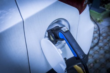 Elektrikli araba aküsünü şarj ediyorum.