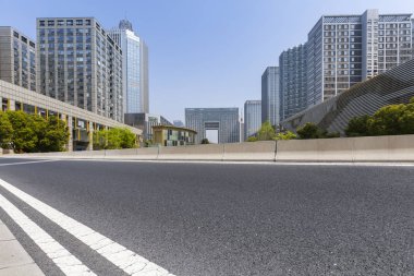 Panoramik siluet ve boş yolu, boş beton zemini olan modern iş binaları.