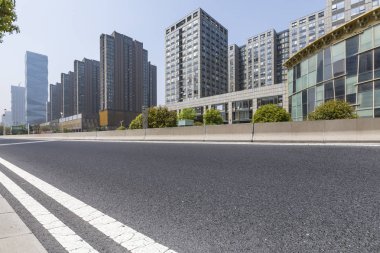 Panoramik siluet ve boş yolu, boş beton zemini olan modern iş binaları.