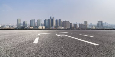 Panoramik siluet ve boş yolu, boş beton zemini olan modern iş binaları.