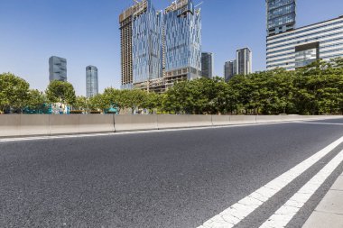 Panoramik siluet ve boş yolu, boş beton zemini olan modern iş binaları.