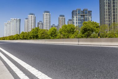 Panoramik siluet ve boş yolu, boş beton zemini olan modern iş binaları.
