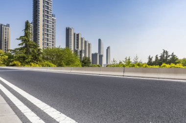 Panoramik siluet ve boş yolu, boş beton zemini olan modern iş binaları.