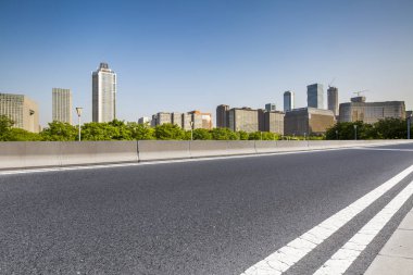 Panoramik siluet ve boş yolu, boş beton zemini olan modern iş binaları.