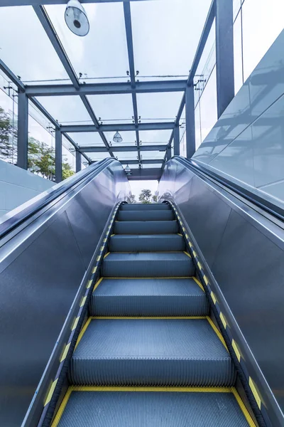 Yürüyen merdiven sarı ve gri çelik hattına yakın çekim.