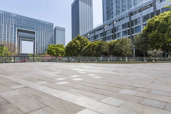 Panoramik siluet ve boş yolu, boş beton zemini olan modern iş binaları.