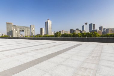Panoramik siluet ve boş yolu, boş beton zemini olan modern iş binaları.