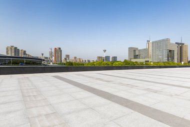 Panoramik siluet ve boş yolu, boş beton zemini olan modern iş binaları.