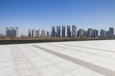 Panoramik siluet ve boş yolu, boş beton zemini olan modern iş binaları.