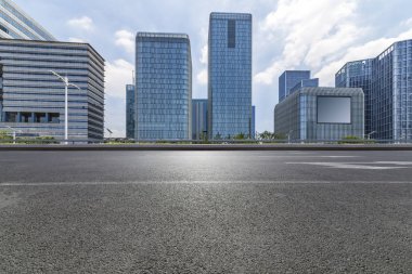 Panoramik siluet ve boş yolu, boş beton zemini olan modern iş binaları.