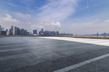 Panoramik siluet ve boş yolu, boş beton zemini olan modern iş binaları.