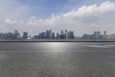 Panoramik siluet ve boş yolu, boş beton zemini olan modern iş binaları.