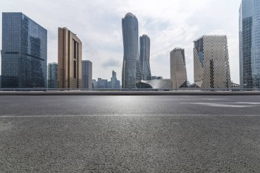 Panoramik siluet ve boş yolu, boş beton zemini olan modern iş binaları.
