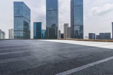 Panoramik siluet ve boş yolu, boş beton zemini olan modern iş binaları.