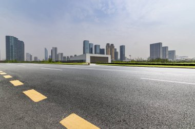 Panoramik siluet ve boş yolu, boş beton zemini olan modern iş binaları.