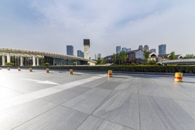 Panoramik siluet ve boş yolu, boş beton zemini olan modern iş binaları.