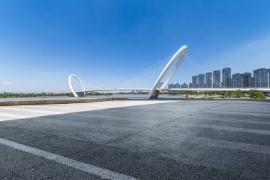 Panoramik siluet ve boş yolu, boş beton zemini olan modern iş binaları.