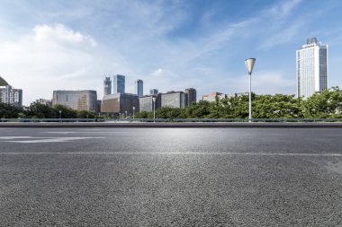 Panoramik siluet ve boş yolu, boş beton zemini olan modern iş binaları.