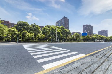 Panoramik siluet ve boş yolu, boş beton zemini olan modern iş binaları.