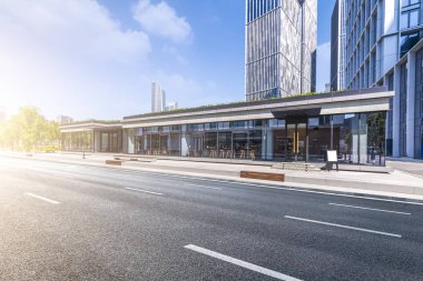 Panoramik siluet ve boş yolu, boş beton zemini olan modern iş binaları.