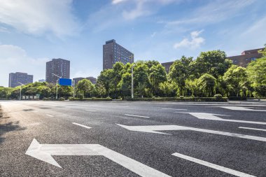 Panoramik siluet ve boş yolu, boş beton zemini olan modern iş binaları.