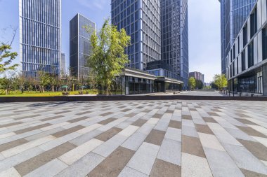 Panoramik siluet ve boş yolu, boş beton zemini olan modern iş binaları.