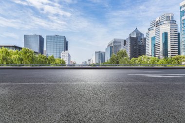 Panoramik siluet ve boş yolu, boş beton zemini olan modern iş binaları.