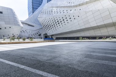 Panoramik siluet ve boş yolu, boş beton zemini olan modern iş binaları.