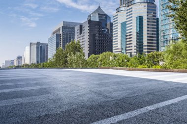 Panoramik siluet ve boş yolu, boş beton zemini olan modern iş binaları.