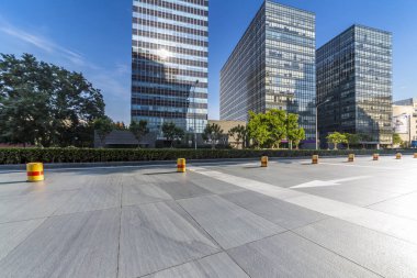 Panoramik siluet ve boş yolu, boş beton zemini olan modern iş binaları.