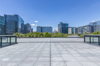 Panoramik siluet ve boş yolu, boş beton zemini olan modern iş binaları.